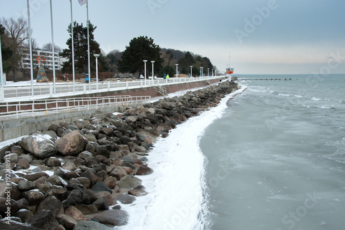Obraz na plátně A snow-covered seaside promenade runs along the partially frozen Baltic Sea