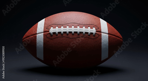 Close-up of an American football ball on a dark studio background, ready for play