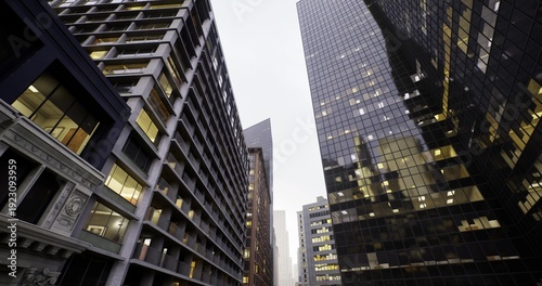 Bild auf Leinwand golden office lights in glass towers framing commuting corridor, early rush impl