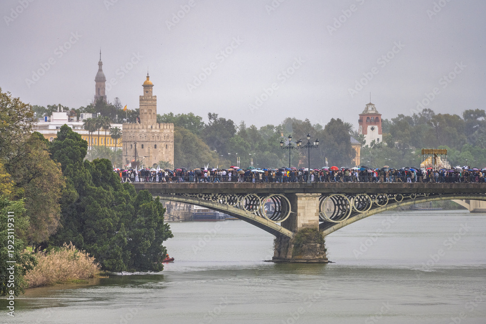 Fototapeta premium Seville Holy Week Rain: Virgen de la Salud Crosses Triana Bridge