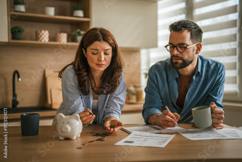 Photos Couple worrying about finances, counting coins from piggy bank