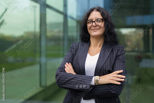 Mature confident businesswoman standing with arms crossed