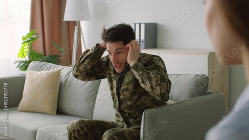 Military mental health. Depressed male soldier wearing camouflage uniform suffering PTSD, talking to psychotherapist at office, need professional help, free space