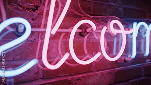 A neon welcome sign mounted on a brick wall in a video