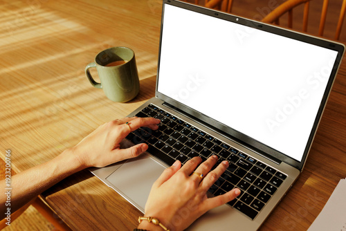 Woman working remotely from home with laptop and coffee