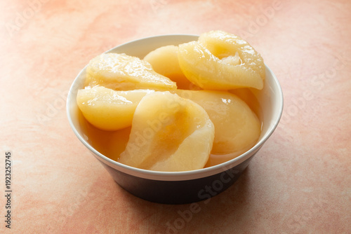 Fotografía A view of a bowl of canned pears halves.