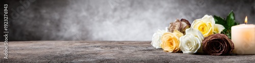 Panel kuchenny z motywem Memorial roses and burning candle on stone table for funeral service or mourning ceremony with dark grey background and copy space for text message or social media banner