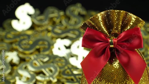 A golden glittery bag with a red bow sits in front of a pile of dollar sign decorations, symbolizing wealth.