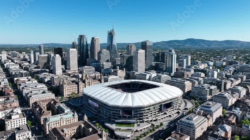 Aerial cityscape with large stadium, modern skyscrapers, and urban architecture