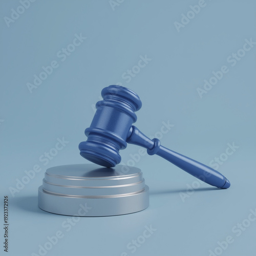 A blue gavel rests on a silver sound block in a courtroom setting.