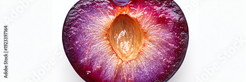 Macro shot of a plum half showing vibrant purple flesh and stone