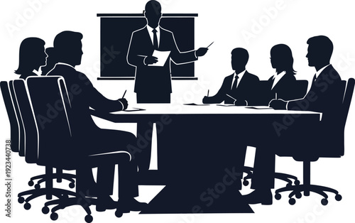 Silhouetted group of business professionals sitting around a large conference table listening to a presenter pointing at a screen.