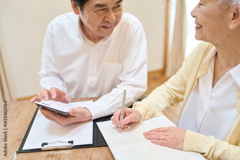 Obraz premium 家計の計算をするアジア人シニア夫婦