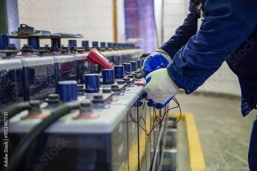 Tableau sur toile Technician performing voltage inspection on emergency battery bank and checking