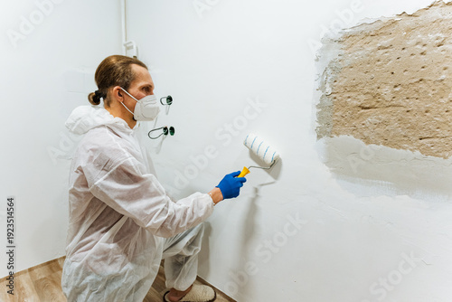 Professional In Protective Gear Painting Fixtures Precisely. Person Wearing Protective Suit Meticulously Brushes Paint On Plumbing Fixtures And Backsplash Area During Home Remodel