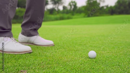 Close up of professional golfer swinging club on a scenic golf course.