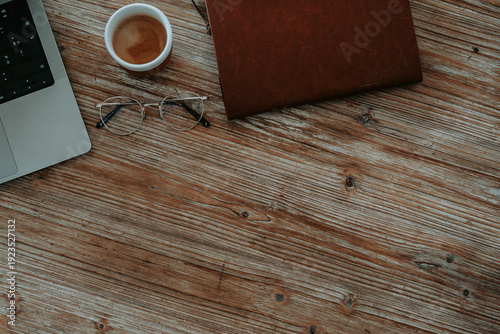 Vue de dessus d'un bureau rustique avec carnet ouvert, lunettes de vue et tasse de café 