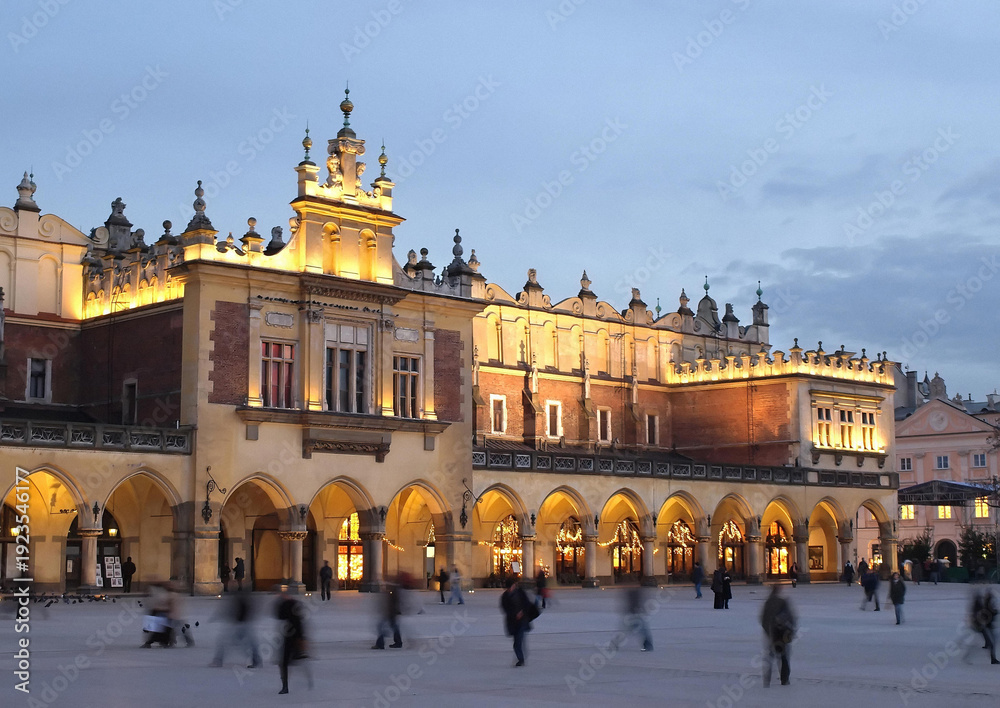 Naklejka premium The Cloth Hall (Sukiennice) in Krakow beautifully illuminated at night with a deep blue twilight sky. Masterpiece of Renaissance architecture on the Main Market Square.