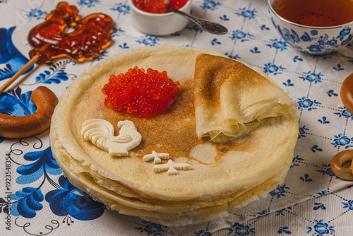 Pancakes on the table next to the samovar and caviar