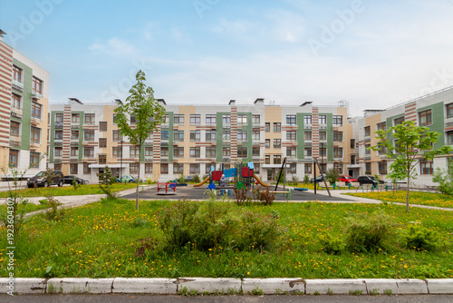 Modern residential complex courtyard with playground and green landscaping