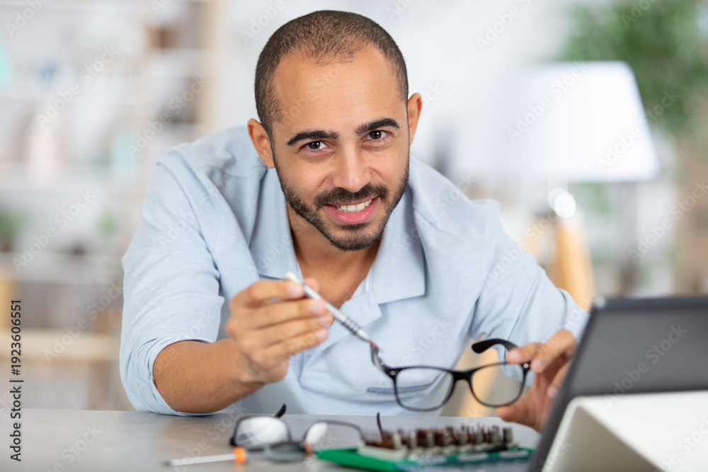 Obraz premium man reapiring a pair of spectacles