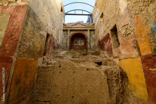 Canvas Print Ancient painted walls and a detailed mosaic niche inside the Suburban Baths of Pompeii, with textured plaster and faded colors under soft daylight