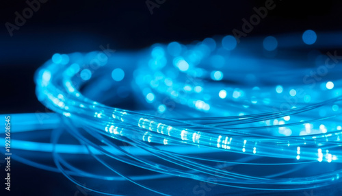 Brilliant blue fiber optic cables transmit data at high speeds across dark digital network connections