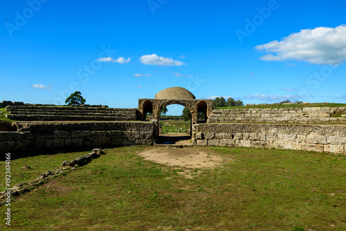Obraz na plátne Historic stone seating and a central arched entrance define the amphitheatre ruins at Paestum, Italy