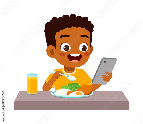 Happy dark skinned boy eating a meal and using a smartphone with a joyful expression at a table