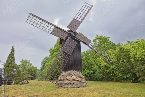 Eemu tuulik (Eemu windmill), traditional wooden post mill in cloudy summer weather, Muhu, Estonia, Europe.