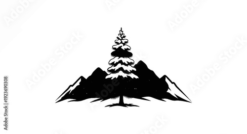 Silhouette of snow-covered pine tree centered between two stark mountains