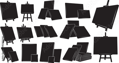 Collection of black canvases on easels and stacked boards