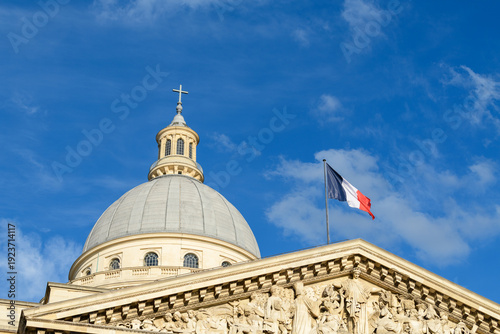 Canvastavla Close-up of the Pantheon dome in Paris with the French flag flying above ornate sculpted pediment details, set against a vivid blue sky with scattered clouds