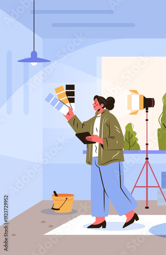 Interior designer choosing color palette modern workspace woman holding swatches and tablet in studio with lighting equipment plants bucket