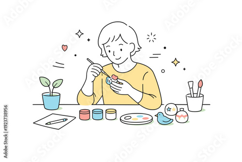 Artisan crafting at home. A person painting or decorating small objects with gentle brush strokes and soft accents. Calm editorial scene