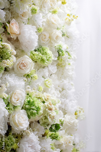 Flower wall full of white roses, peonies, hydrangeas, and green foliage, forming a delicate floral background