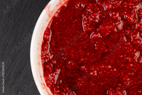 juicy red fresh grated strawberries in a bowl, a sweet, delicious and juicy dessert from natural berries, a large bowl with grated ripe strawberries while making jam or desserts