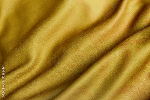 A smooth, mustard yellow velvet fabric texture with elegant pleat details.