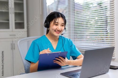 Fotografie Smiling healthcare professional in scrubs telecommuting, providing online medica