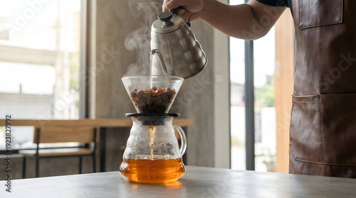 Professional Barista Preparing Amber Cascara Coffee Cherry Tea in Glass Pour-over Carafe with Rising Steam in Minimalist Modern Cafe Setting with Soft Morning Light