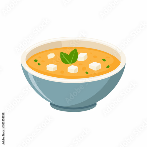 Bowl of creamy soup with cheese cubes and herb garnish