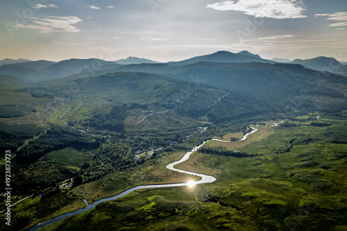Quadro su tela Aerial view of a winding river through the Scottish Highlands landscape at sunse