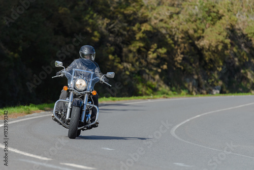 biker on a custom classic motorcycle rides down the road, road traffic