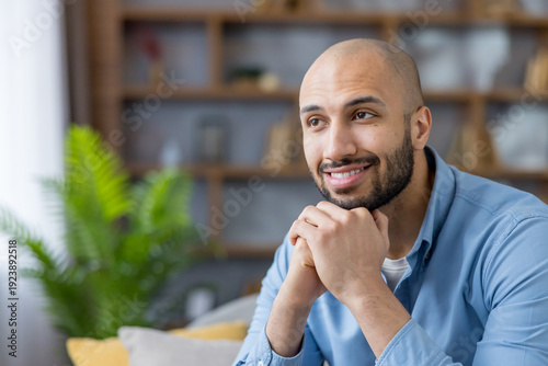 Canvas Print Content bald man in a blue shirt smiling and looking away, daydreaming and conte