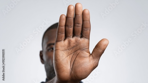 Person with hand up in a stop gesture.