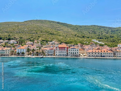 Croatia's island of Vis in Dalmatia. The historic town of Vis on a summer day. Mountains and forests, and the azure Adriatic Sea. Houses and church towers.