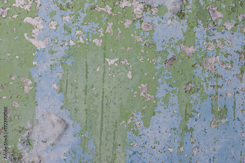 Peeling paint on the wall. Old concrete wall with cracked flaking paint. Weathered rough painted surface with patterns of cracks and peeling. High resolution texture for background and design. Closeup