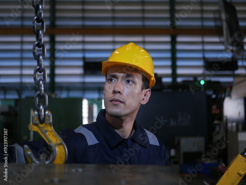 Automotive engineer inspecting machinery in parts manufacturing factory