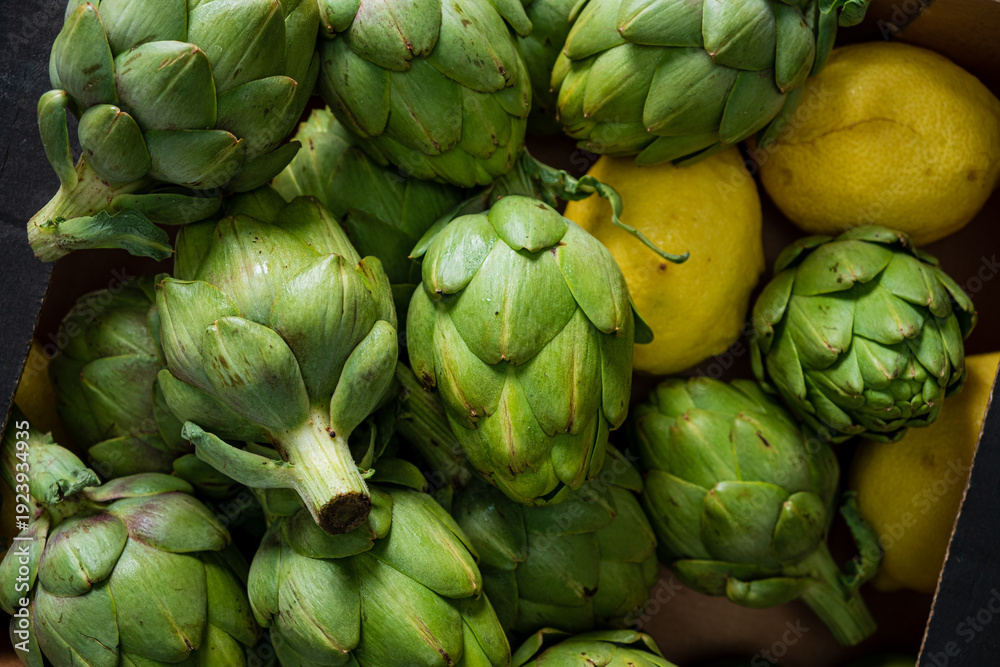 Fototapeta premium Plump green artichokes nestle beside bright lemons, ready for a culinary adventure in the kitchen