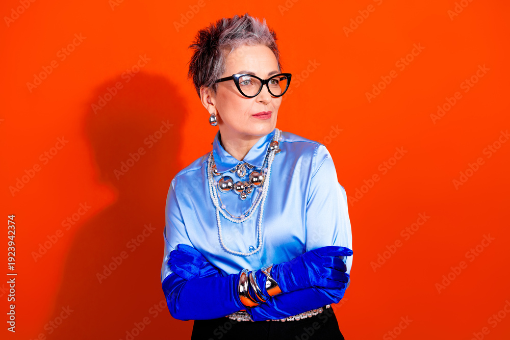 Ταπετσαρία Elegant mature lady in blue silk shirt with bold jewelry and glasses against viv